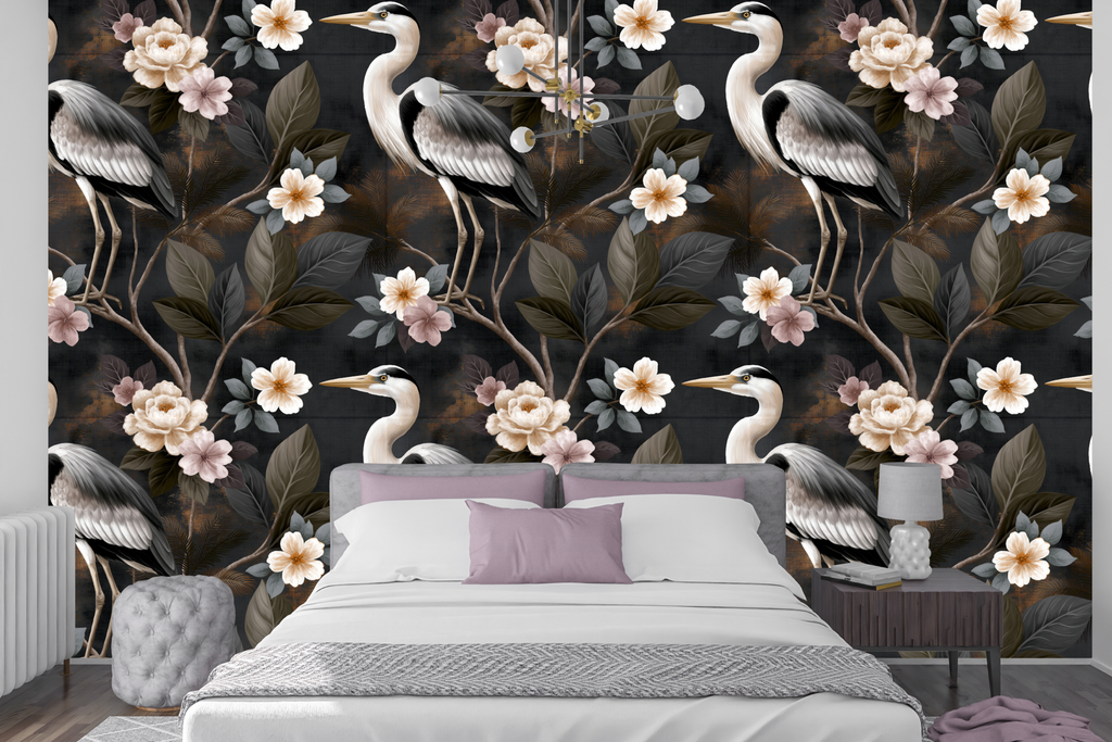 Dark chinoiserie heron wallpaper styled as an atmospheric bedroom feature wall with velvet headboard, warm brass lighting, and ivory linen bedding — peel and stick or traditional paste wallpaper by WallpaperPixi
