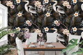 Dark chinoiserie wallpaper featuring white herons with detailed plumage, ivory and blush camellia blossoms, gnarled dark branches, and olive bronze foliage on a richly textured charcoal ground with copper-gold accents — premium moody heritage wallpaper by WallpaperPixi