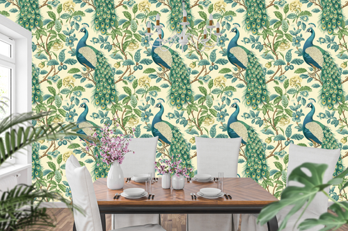 Chinoiserie peacock wallpaper featuring magnificent peacock birds with detailed emerald and sapphire plumage, cascading golden-eyed tail feathers, blue and ivory botanical blossoms, trailing branches, and rich green foliage on a warm ivory ground — premium heritage bird wallpaper by WallpaperPixi