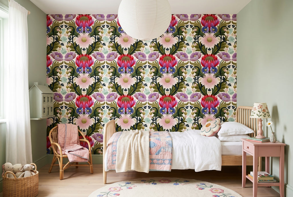 Folk botanical maximalist wallpaper styled as a joyful living room feature wall with jewel-toned velvet sofa, rattan accessories, and warm natural light — peel and stick or traditional paste wallpaper by WallpaperPixi