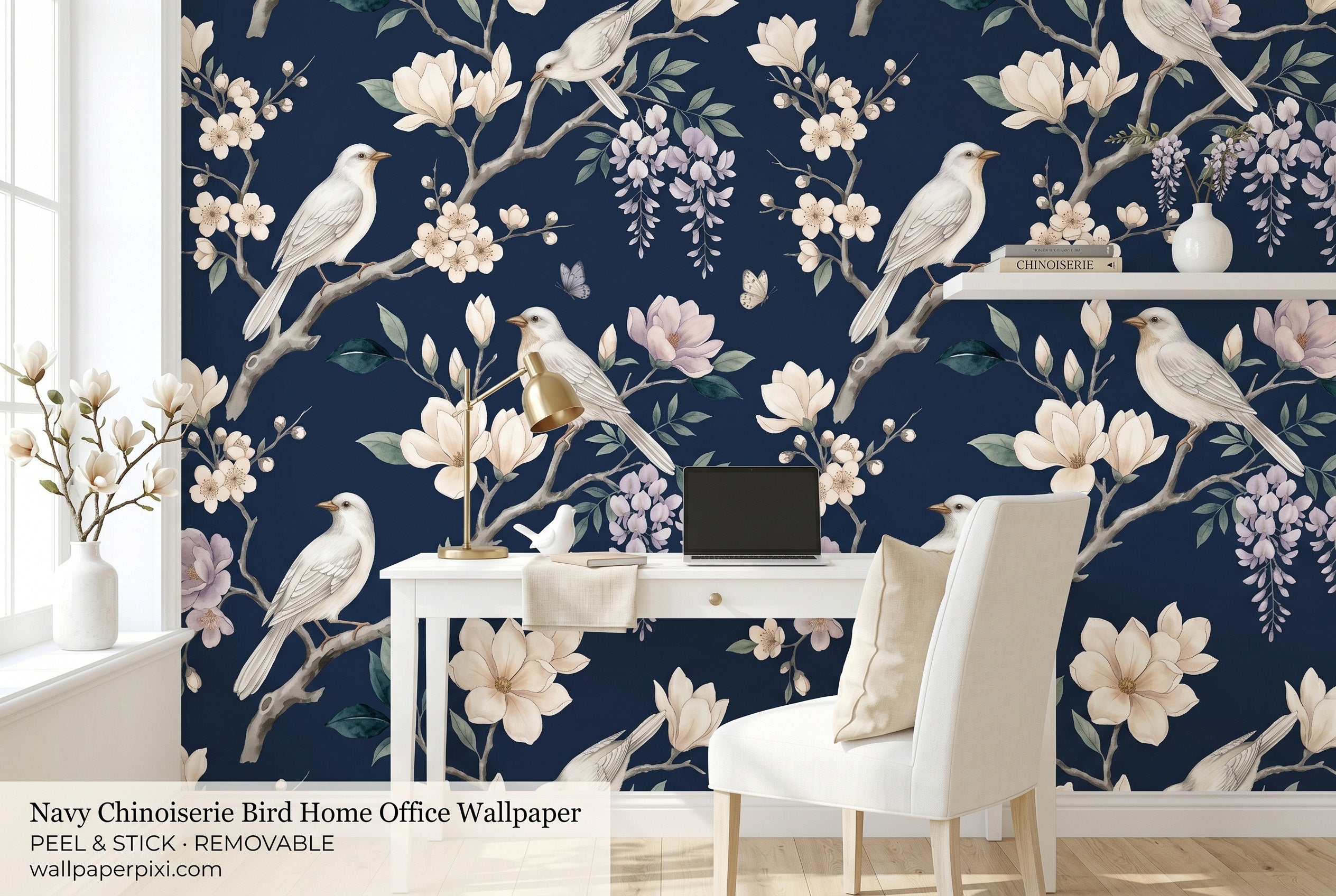 Navy chinoiserie bird wallpaper in a bright home office with a white desk brass lamp cream chair and fresh magnolia branch