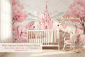 Pink unicorn castle wall mural in a bright girls nursery with a white crib blush pink bedding fairy lights and a unicorn plush toy.