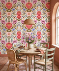 Vintage botanical damask wallpaper featuring a large coral-pink protea bloom, mauve cosmos flowers, periwinkle cornflowers, mint wildflowers, and sweeping olive acanthus leaves with gold dot accents on a warm antique cream background — premium floral wallpaper by WallpaperPixi