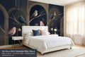 Art deco bird midnight blue wall mural in a bright elegant bedroom behind a white upholstered bed with navy and blush cushions and warm brass lighting