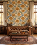 Art Nouveau vintage floral wallpaper featuring richly detailed amber gold chrysanthemum blooms, blue-grey fan-shaped ginkgo leaves, and ornamental scrollwork on an antique cream background — premium botanical pattern by WallpaperPixi