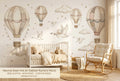 Neutral swan hot air balloon wall mural in a bright gender-neutral nursery with a white crib warm beige bedding rattan rocking chair and natural wood accessories