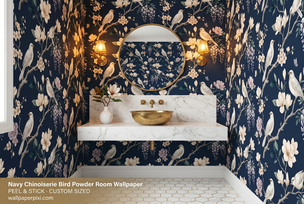 Navy chinoiserie bird blossom wallpaper in a bright powder room with a white marble vanity brass fixtures and a round gold mirror