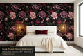 Dark floral black peony wallpaper in a bright dramatic bedroom with a white upholstered bed cream bedding burgundy velvet cushion and warm brass lighting