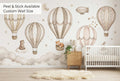 Hot air balloon nursery wallpaper mural in a Scandinavian minimal baby room with natural wood and cream tones