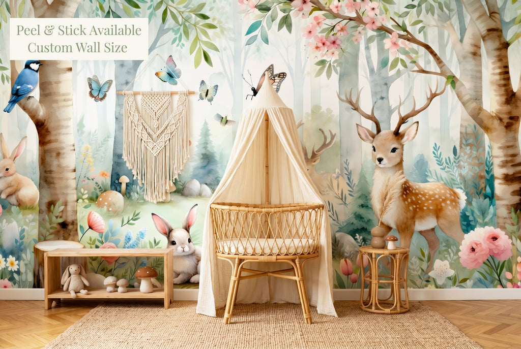 Woodland nursery wallpaper mural with deer rabbits and birch trees in a boho nursery with rattan crib and macramé decor